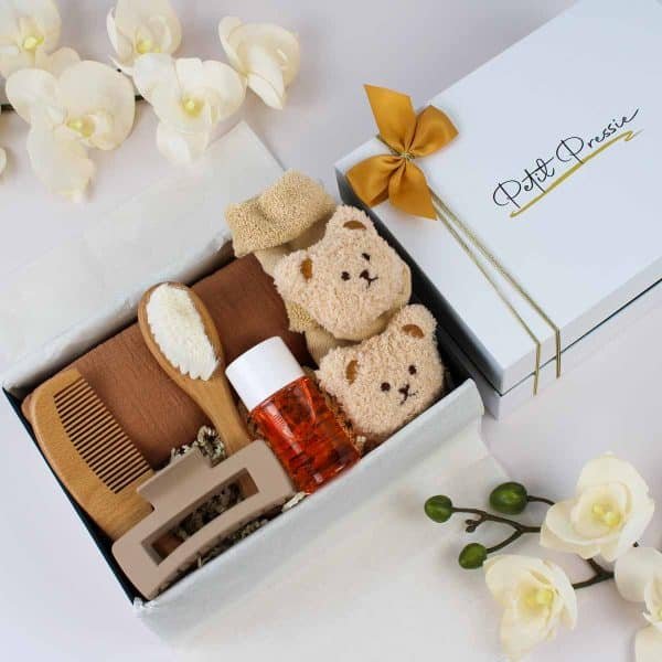 Baby neutral gift box with teddy bear socks, grooming set, amber bottle, and Petit Pressie packaging