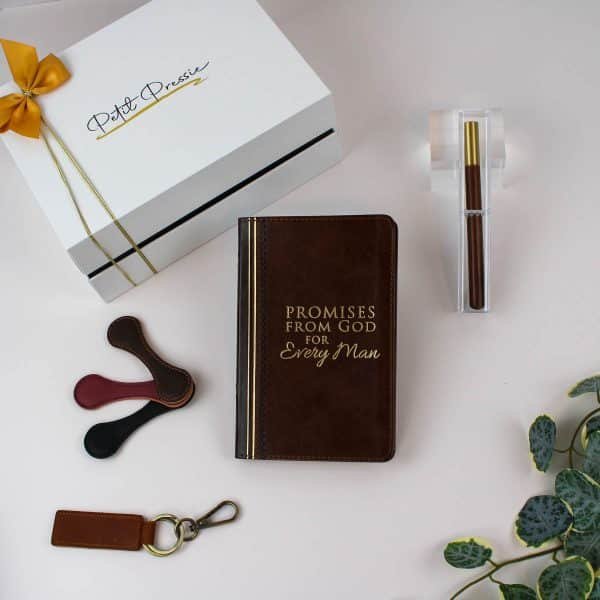 Contents of the men’s gift box displayed outside the box, including a leather-like book, a wooden pen, a leather keychain, and cord organizers, ideal for gifting.