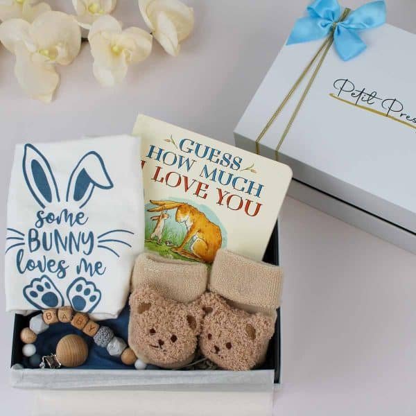 Baby gift box with "Guess How Much I Love You" book, bunny bodysuit, teddy bear socks, and wooden pacifier clip