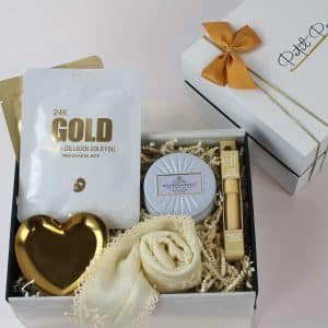 Golden Glow Pamper Gift Box with 24K gold mask, candle, gold dish, beauty products, and scarf.