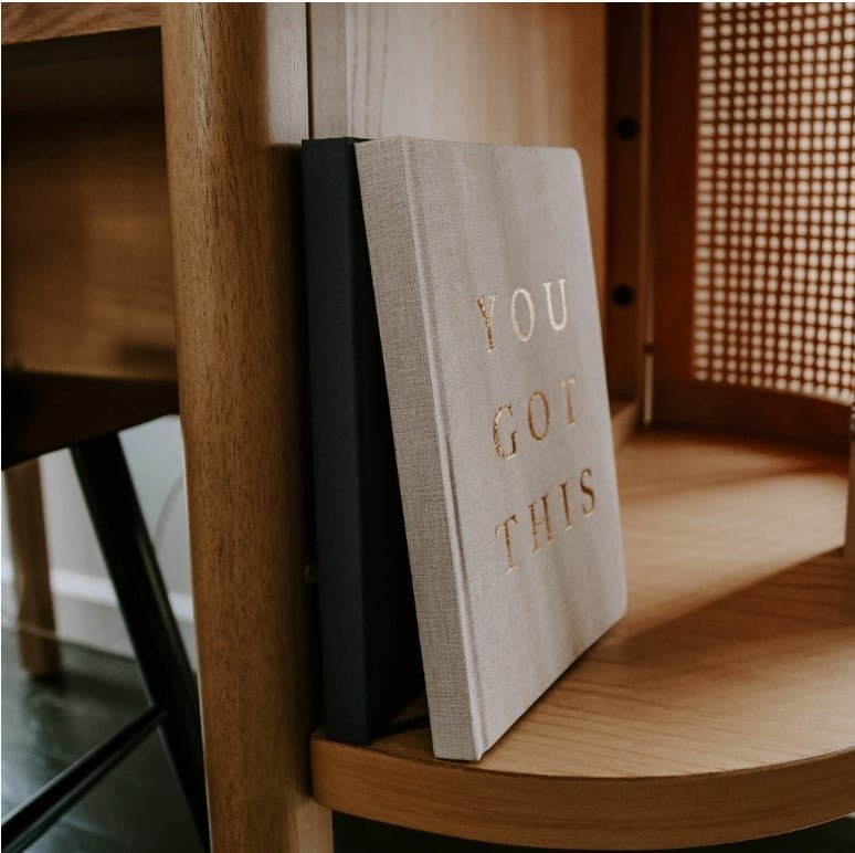 You Got This Gift Box - Motivational Essentials Set 3 Motivational notebook with “YOU GOT THIS” embossed in gold on a wooden shelf