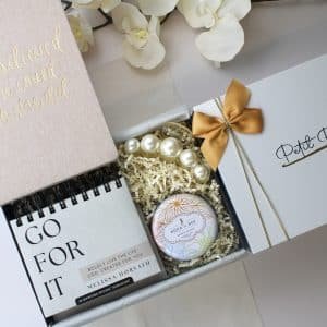 Faith-based women’s gift box with journal, calendar, candle, and pearl clip in white packaging
