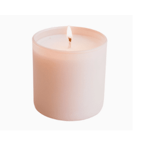 Minimalist blush pink candle in frosted glass container with a soft flame, ideal for relaxation and self-care rituals