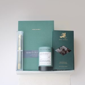 Luxury tea and chocolate gift box for her with green journal, English breakfast tea, artisanal dark chocolate, and gold pen – Petit Pressie flat lay